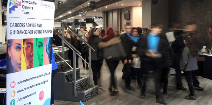 group of students walking around stalls at a careers fair