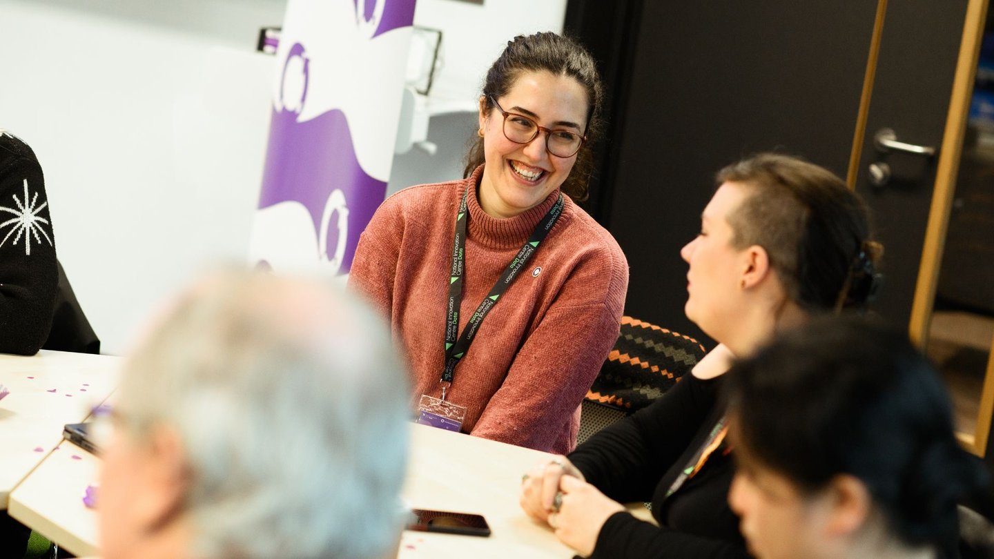 Women sat smiling around a table in The Catalyst at a NICD event